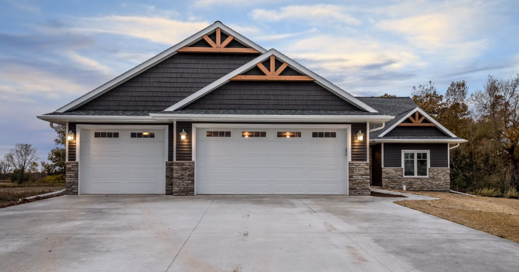 Modern house with three white garage doors.
